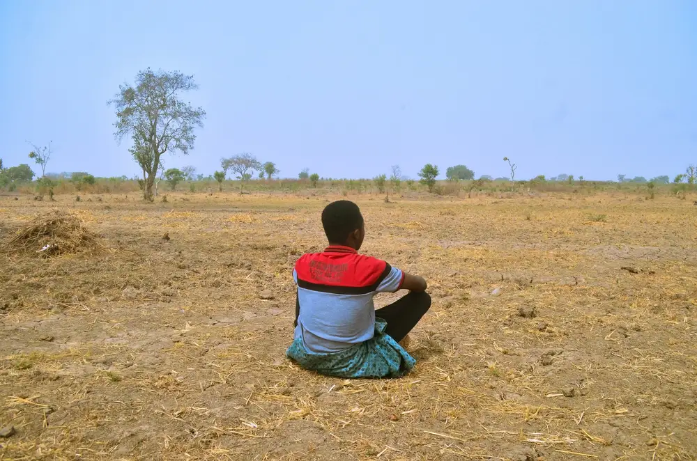 back view of a man sitting on a dry land
