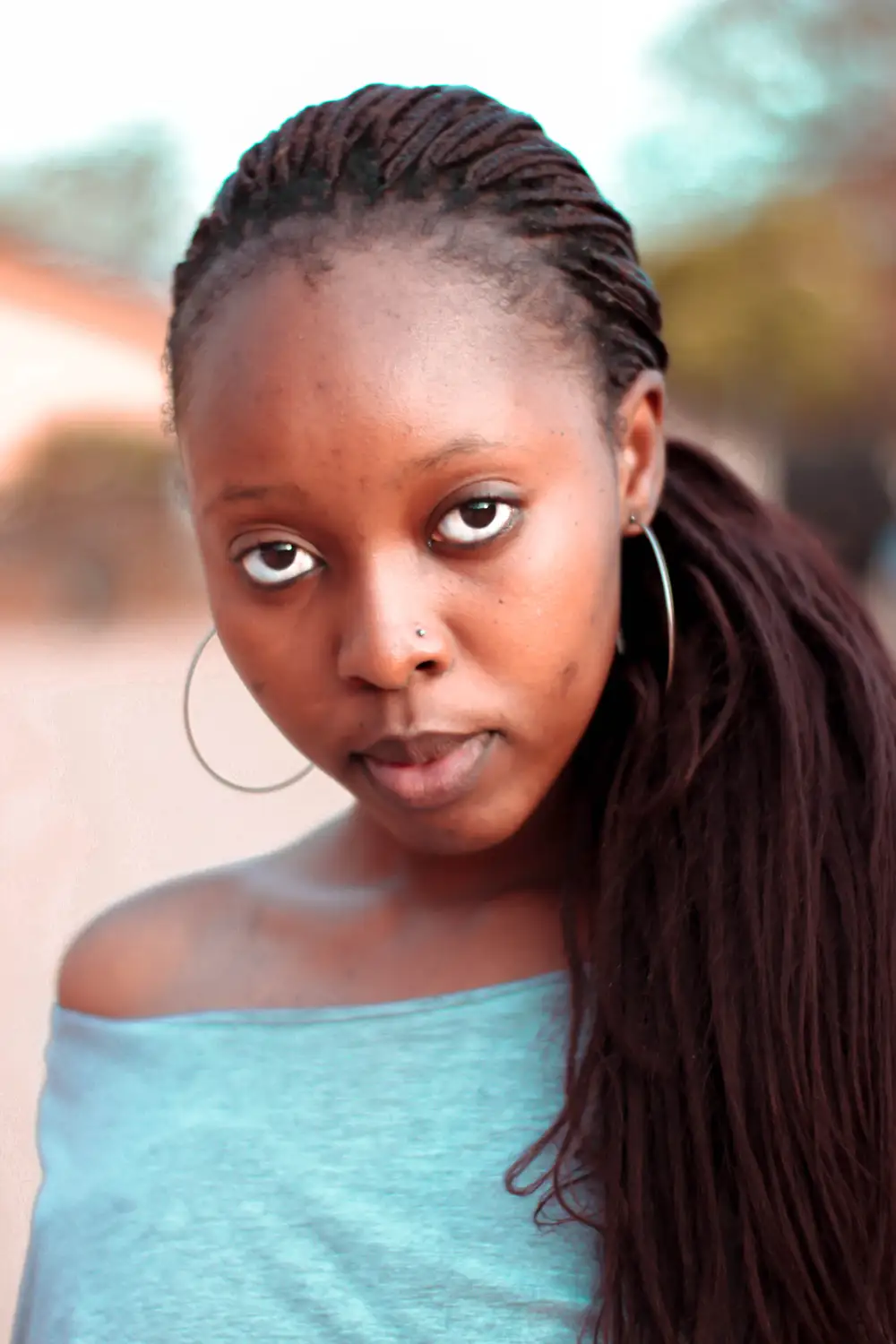 Beautiful black girl with big eyes, nose piercing and big ear silver rings