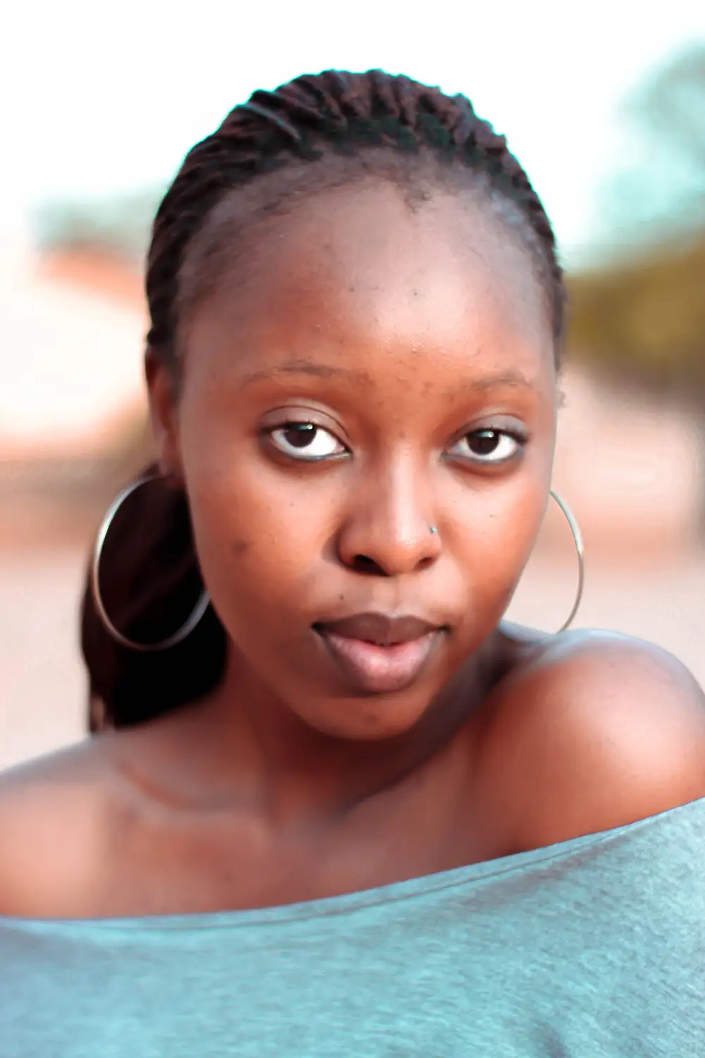 Beautiful black girl with big eyes, nose piercing and big ear silver rings