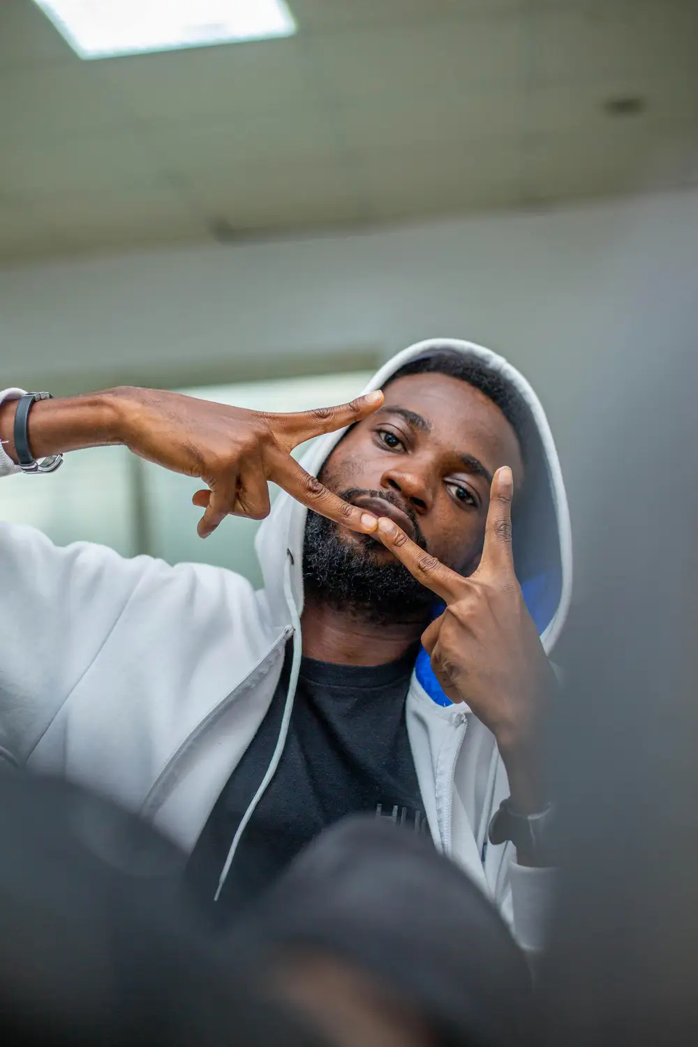 man on tecno white hoodie poses for the camera
