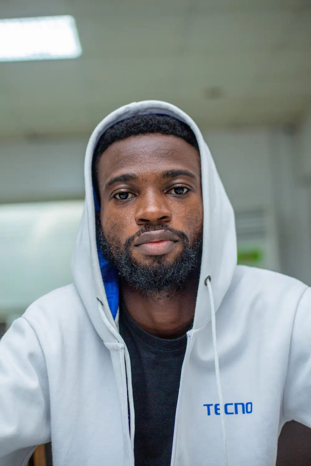man on tecno white hoodie poses for the camera