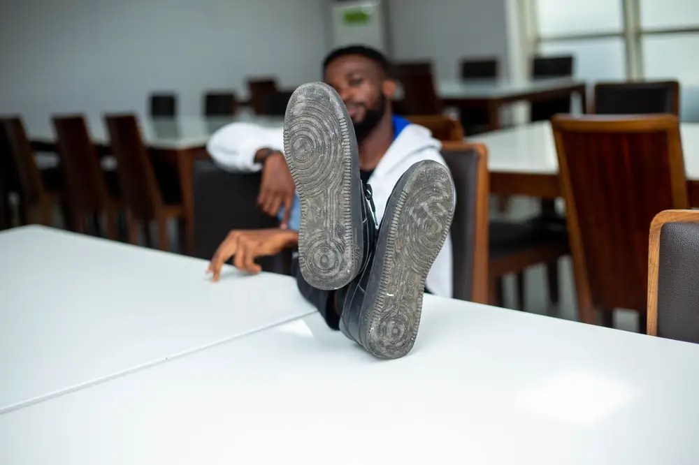 man puts his shoes on the table