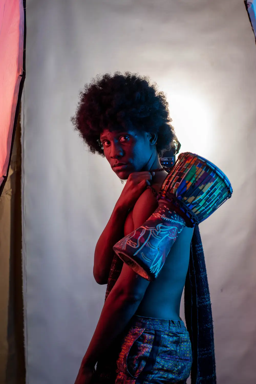 model on afro holds his drum from the back