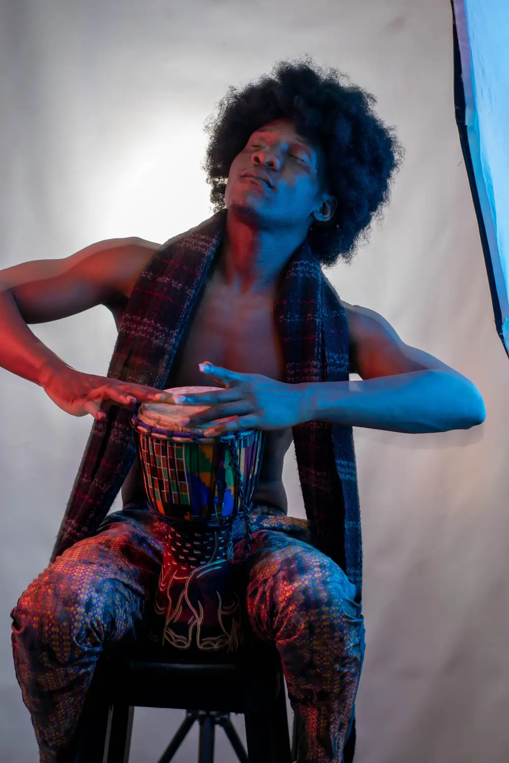 model on afro hairstyle enjoys playing his drum