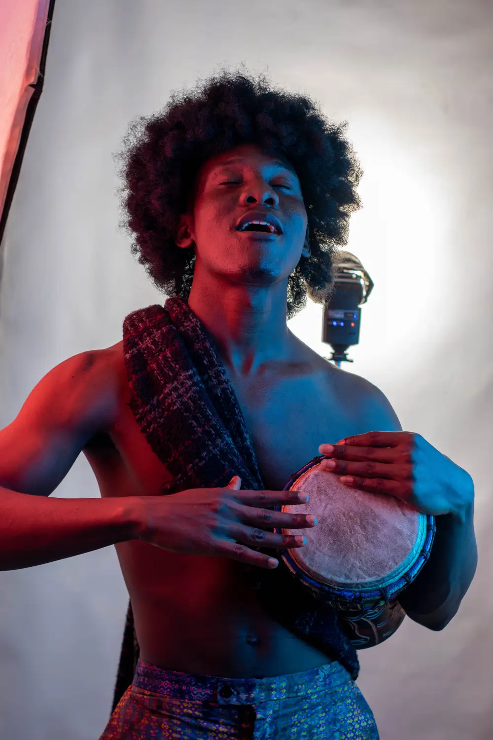model on afro hairstyle plays drum 4