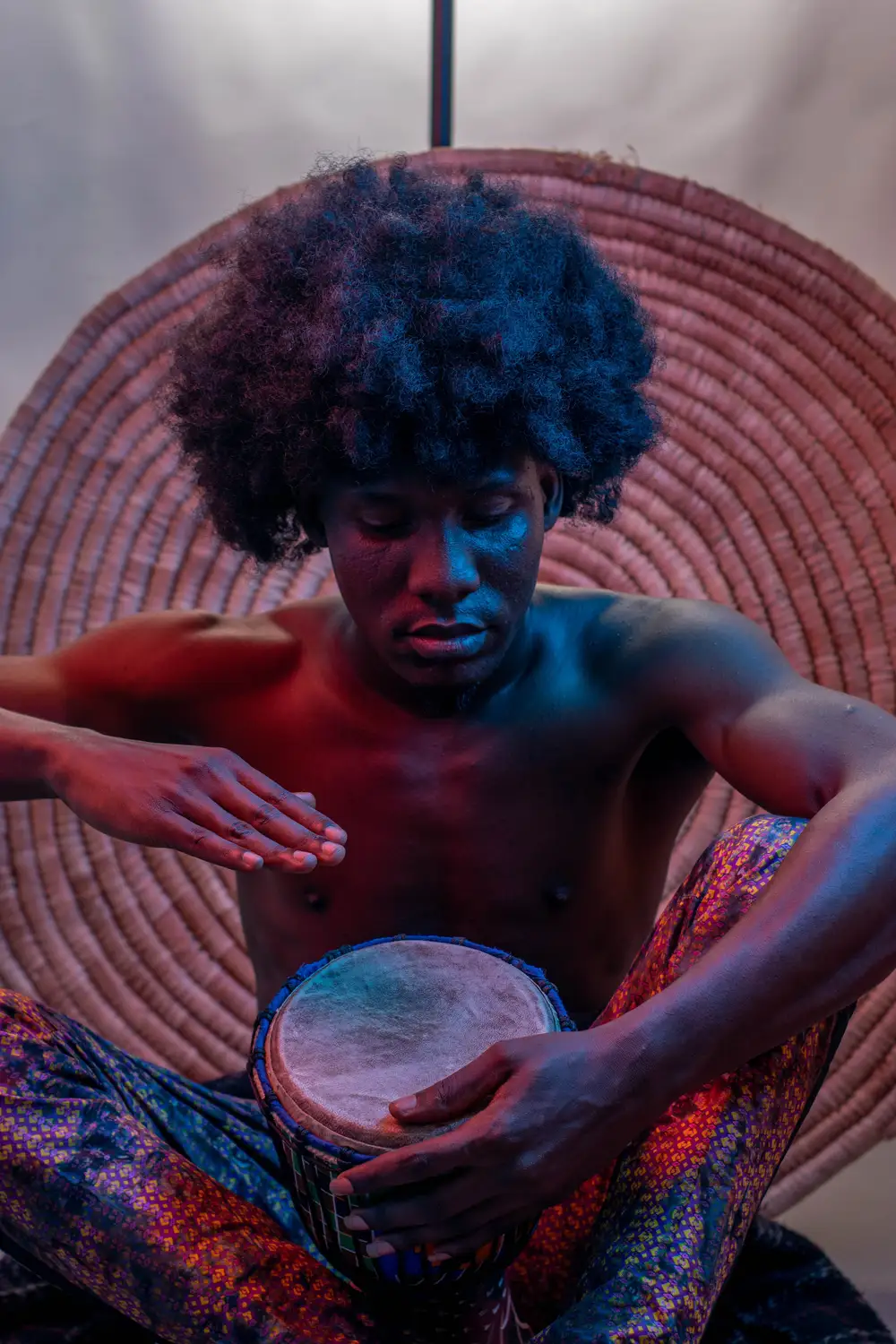 model on afro hairstyle plays his drum