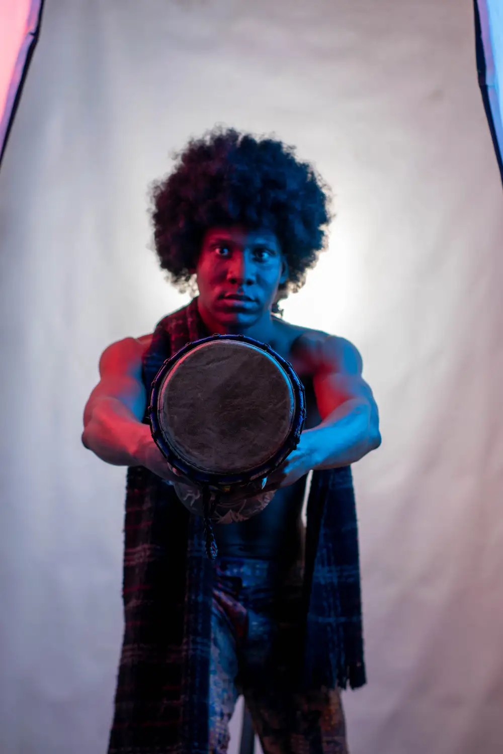 model on afro hairstyle holds his drum