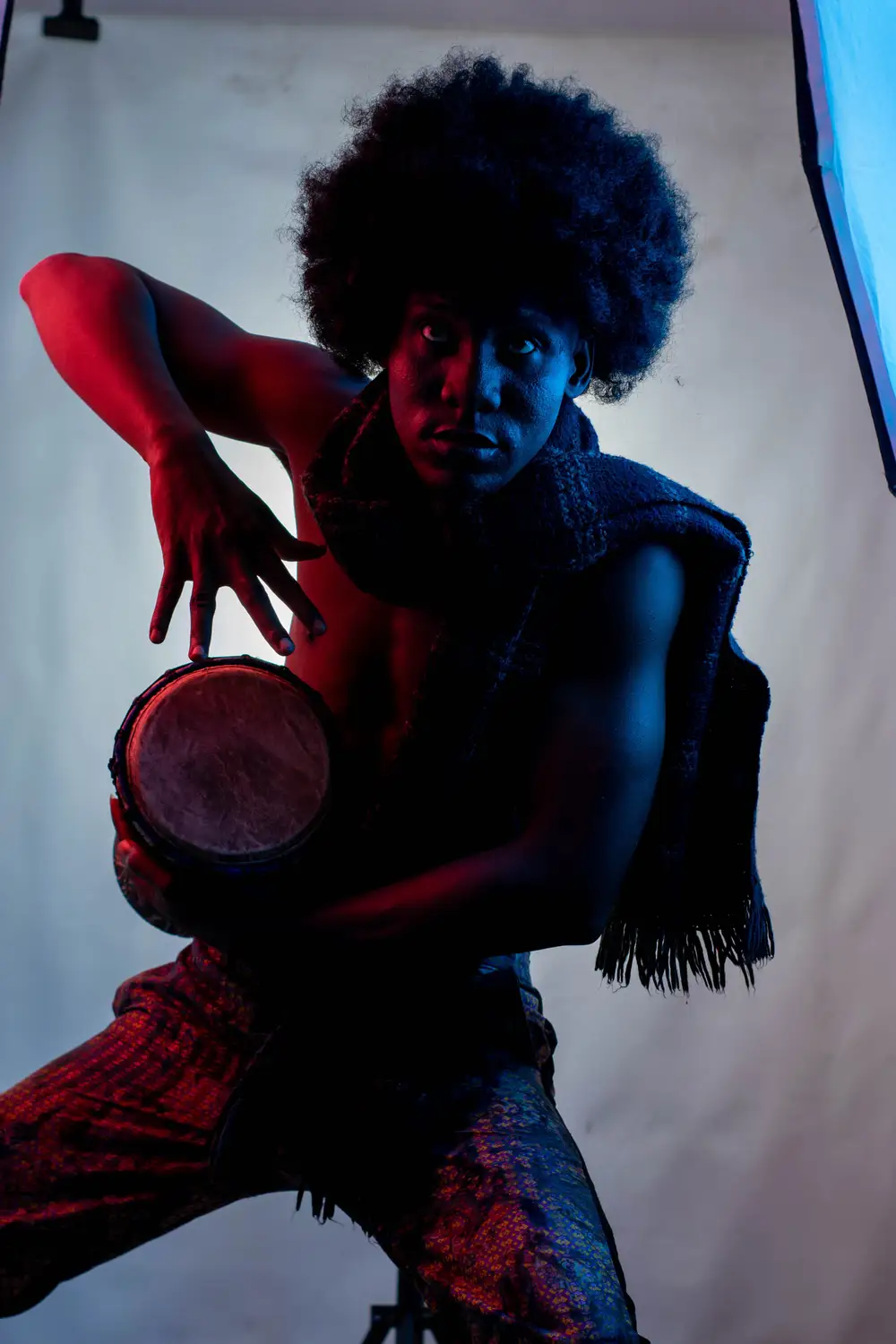 model on afro hairstyle plays drum 3
