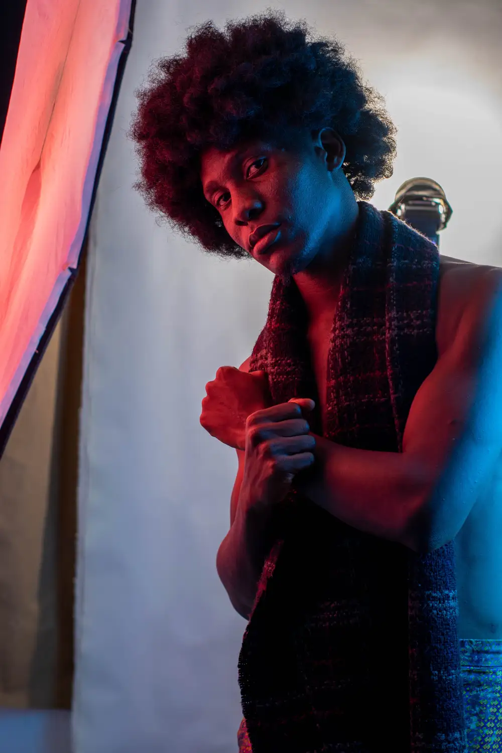 model on afro hairstyle crosses his hands