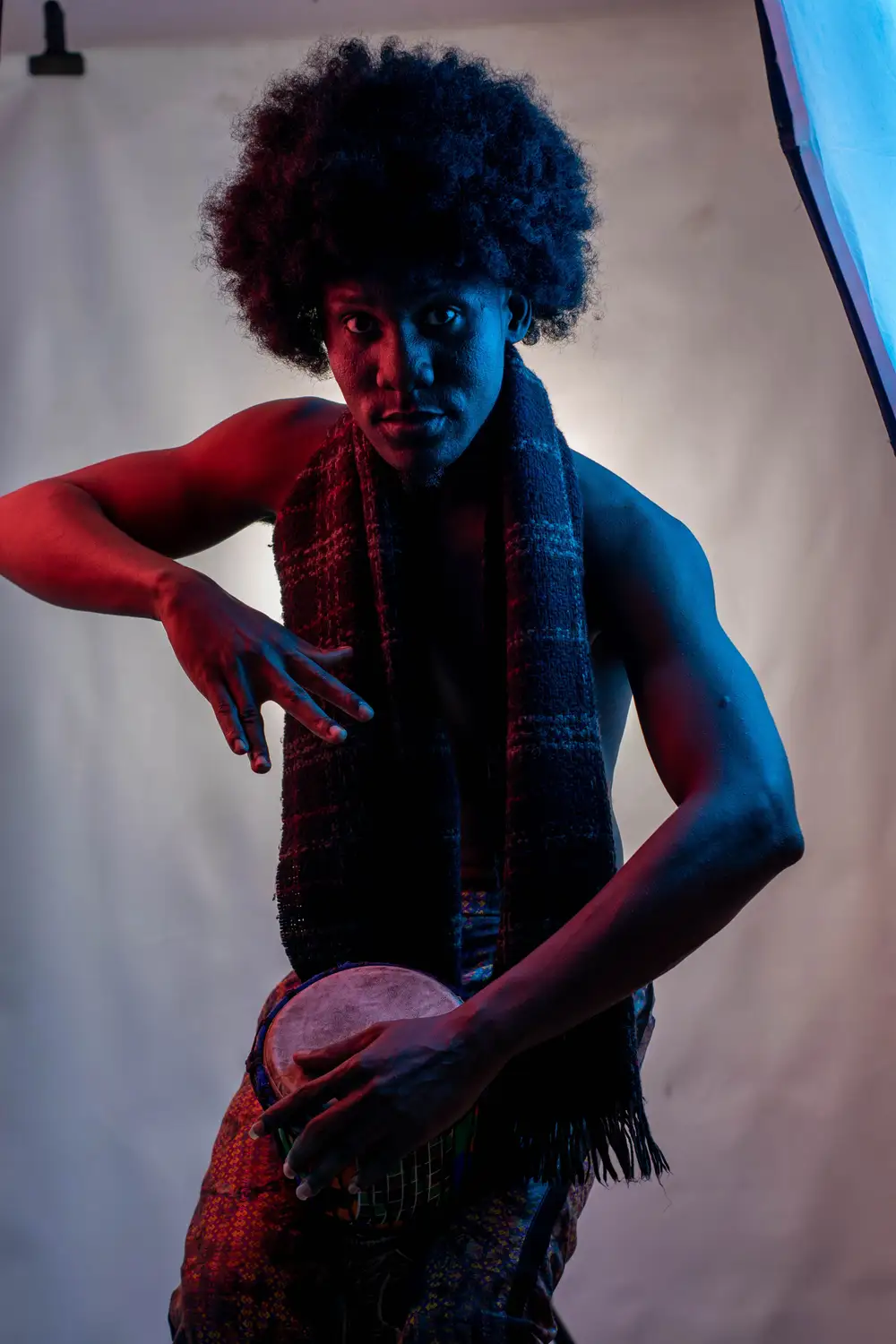 model on afro hairstyle plays drum