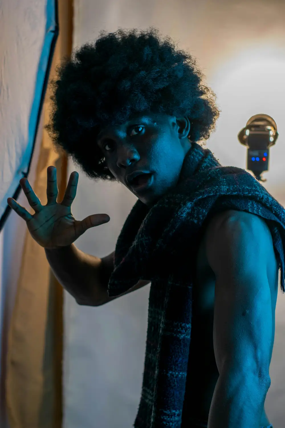 model on afro hairstyle raises his hands and opens his mouth