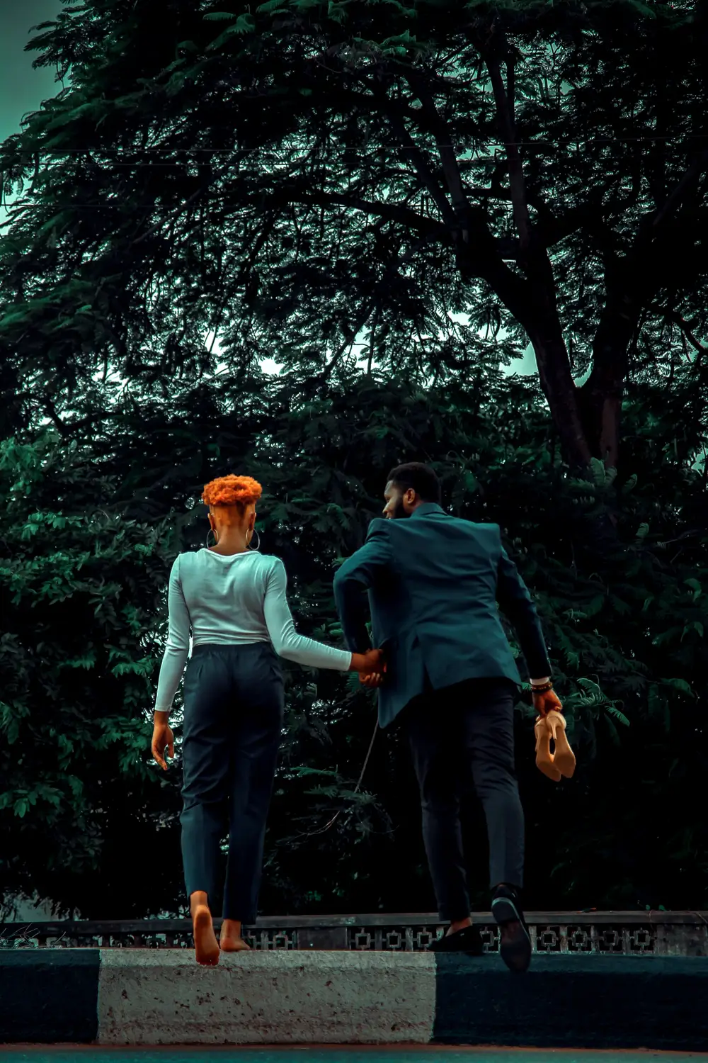 Back view of young couple walking in the park