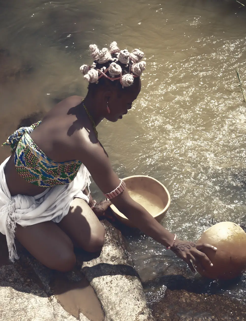 Girl fetching water from a river