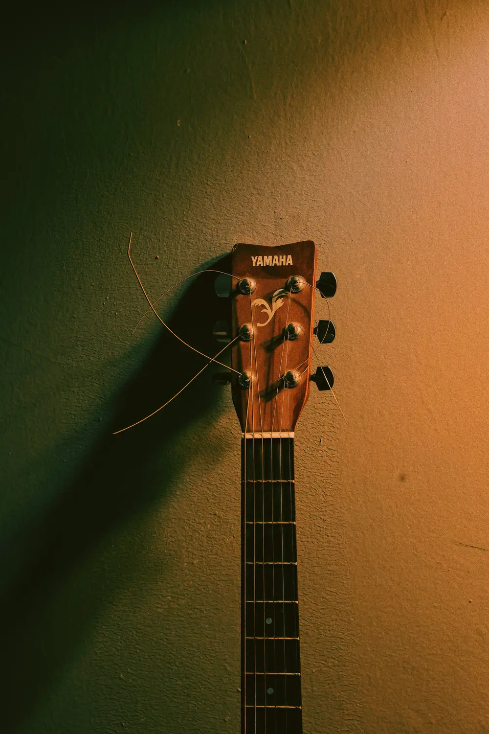 yamaha guitar hanging against the wall