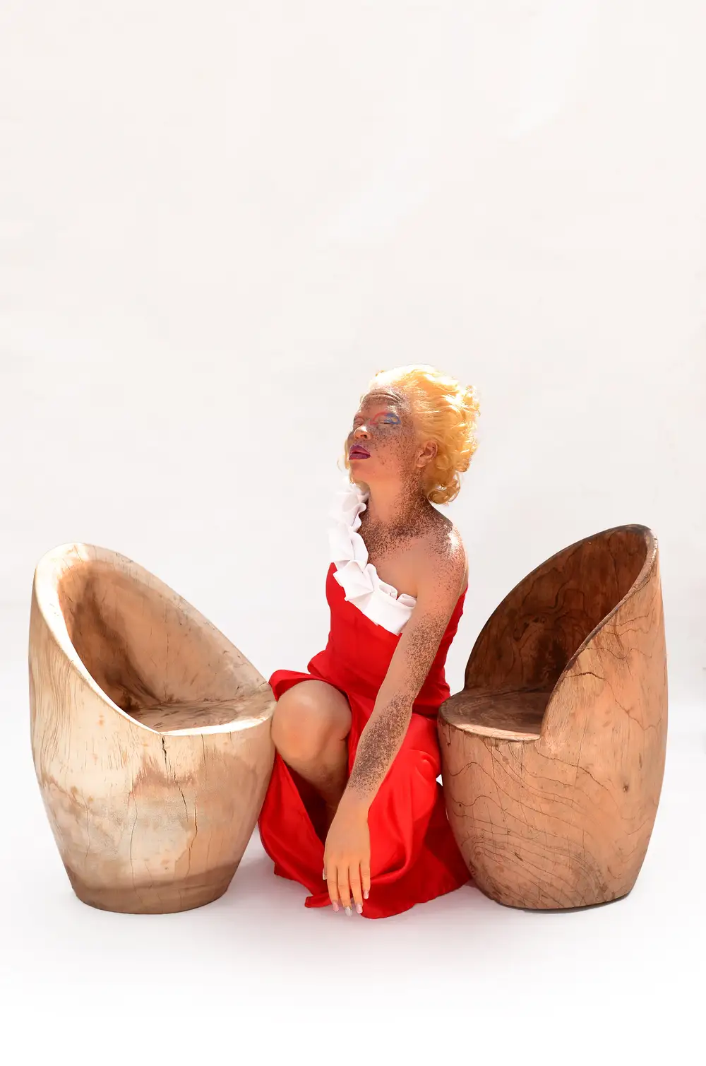 Lady sitting between two wooden chairs