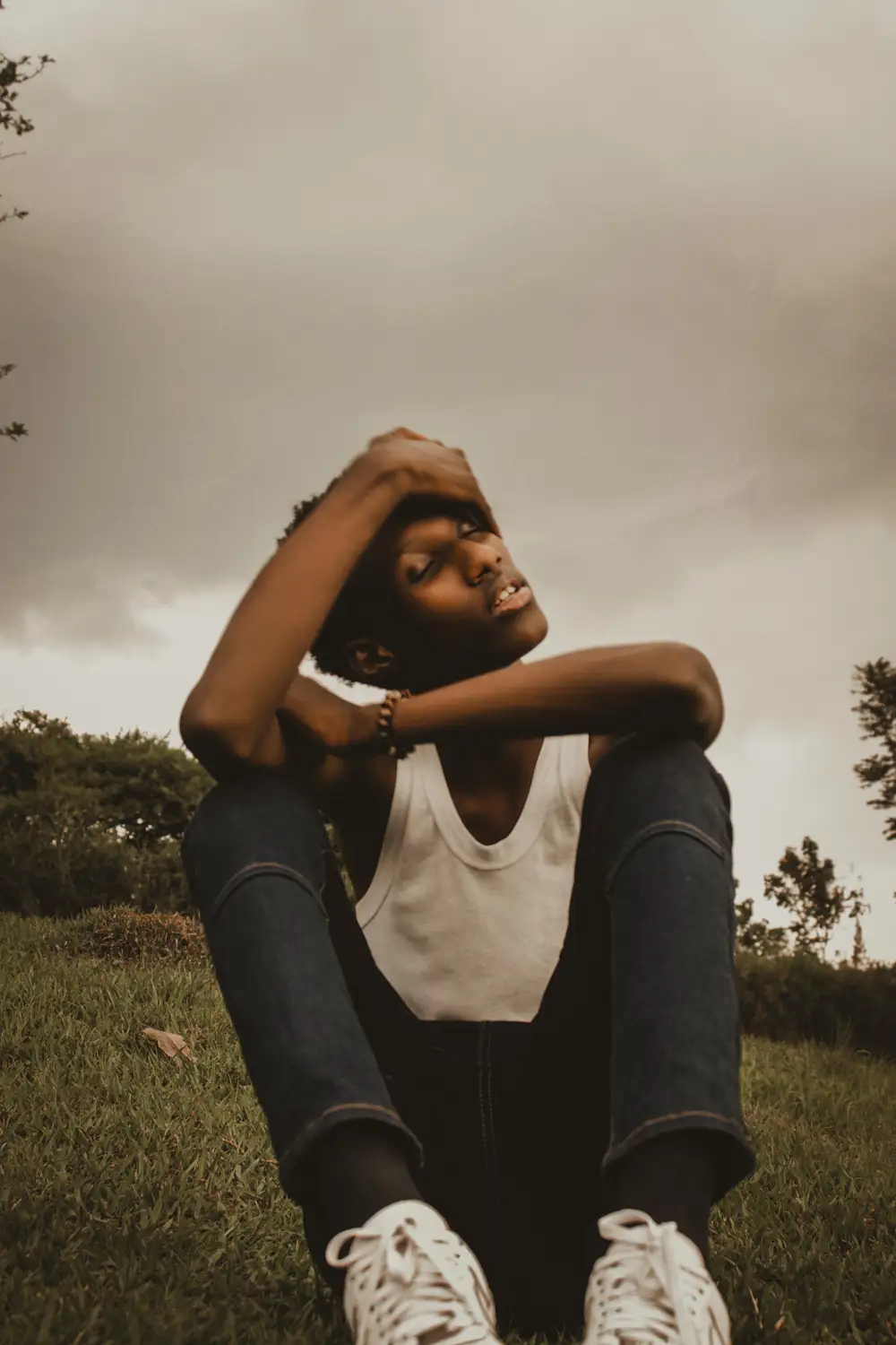 Boy wearing a singlet sitting on grass