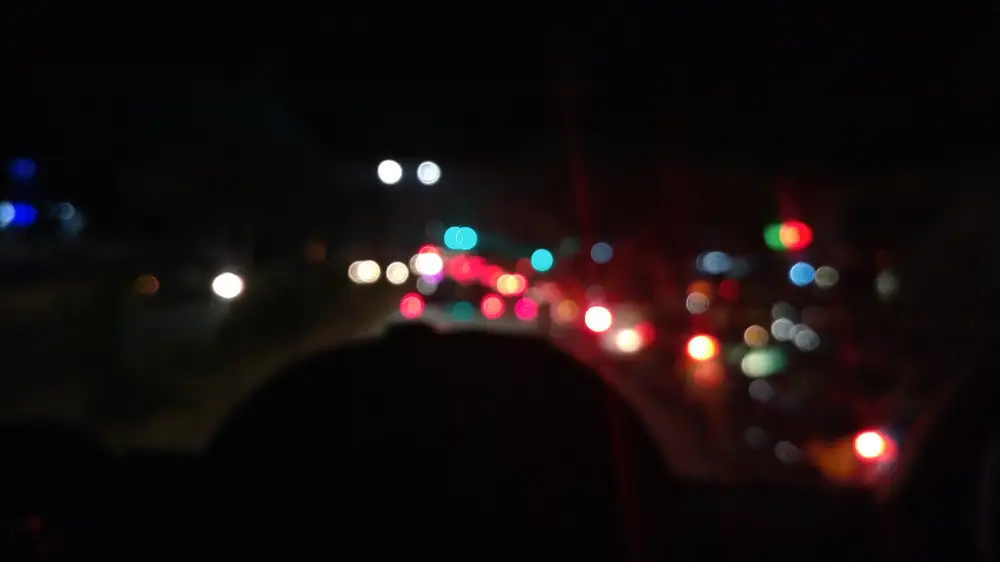 Blurred view of a road with multiple lights in the background