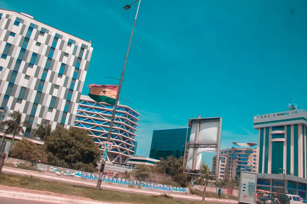 A street view showing a ghananian flag on a pole