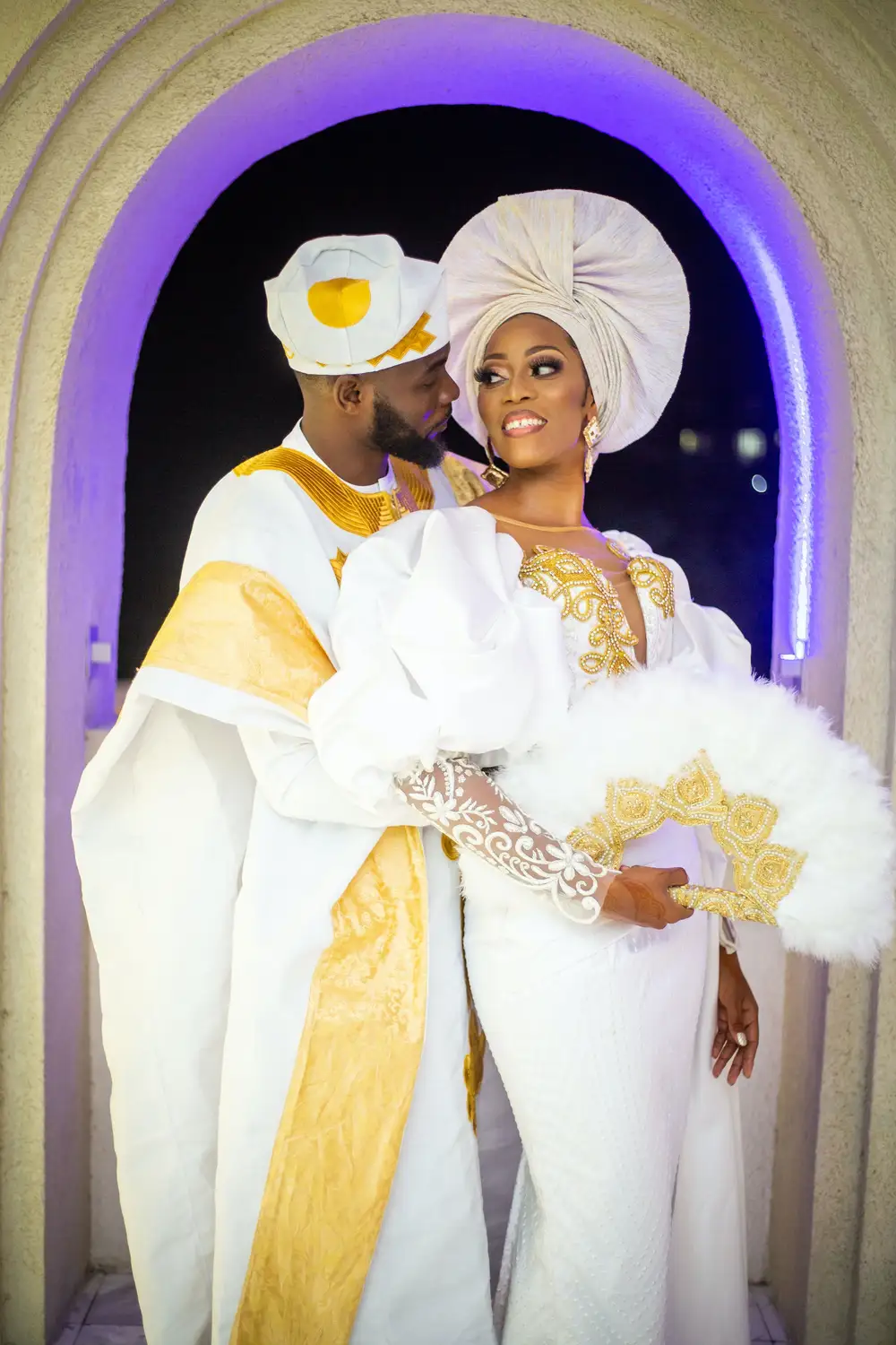 Groom holding bride from behind, bride smiling looking at groom