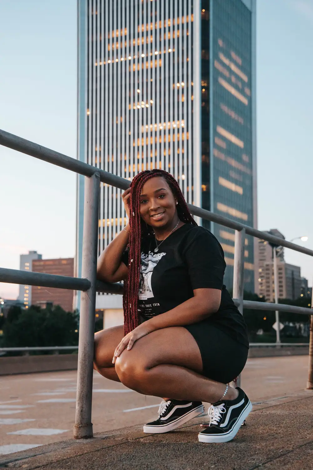 Young smiling lady squatting by the side of the road