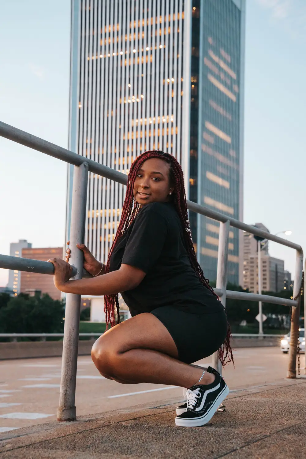 Young lady squatting and holding a rail