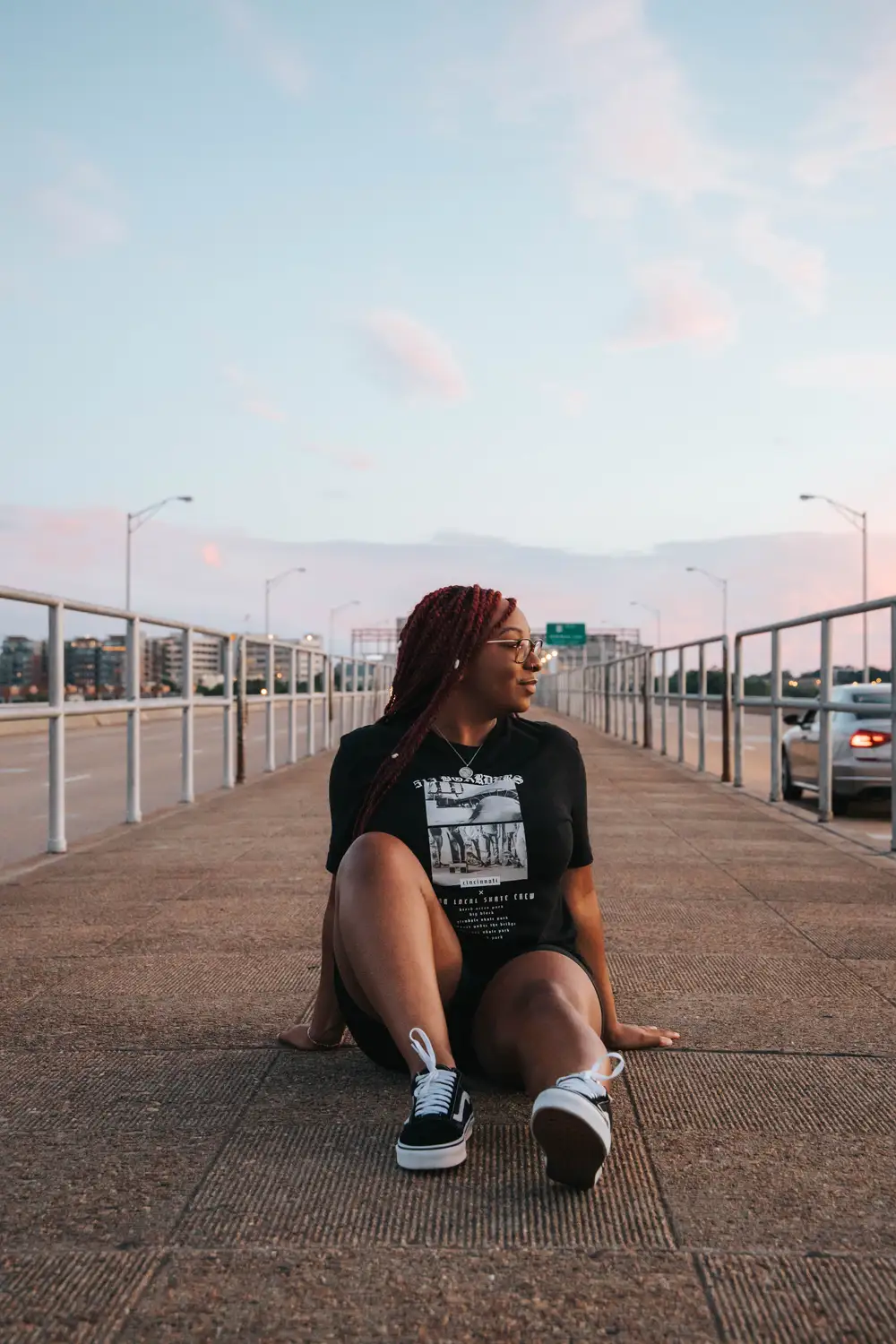 Lady looking to her side, sitting on the road