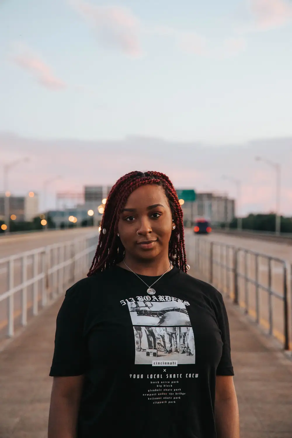 Young woman standing between the road