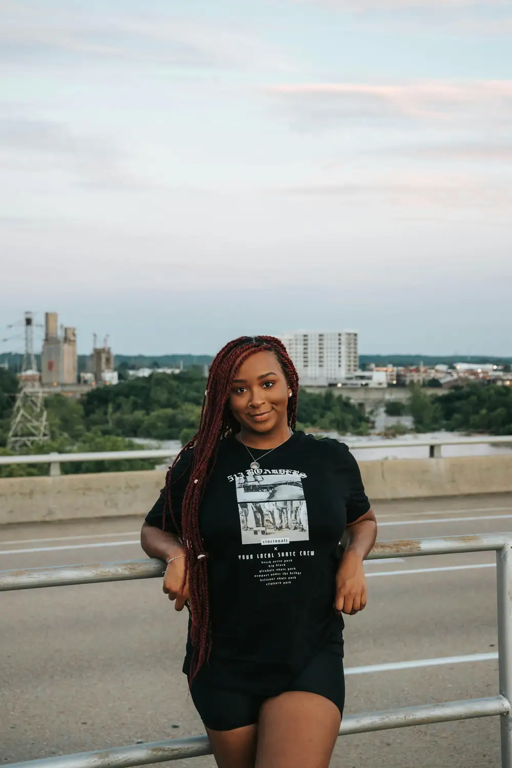 Lady wearing a black shirt leaning on a rail