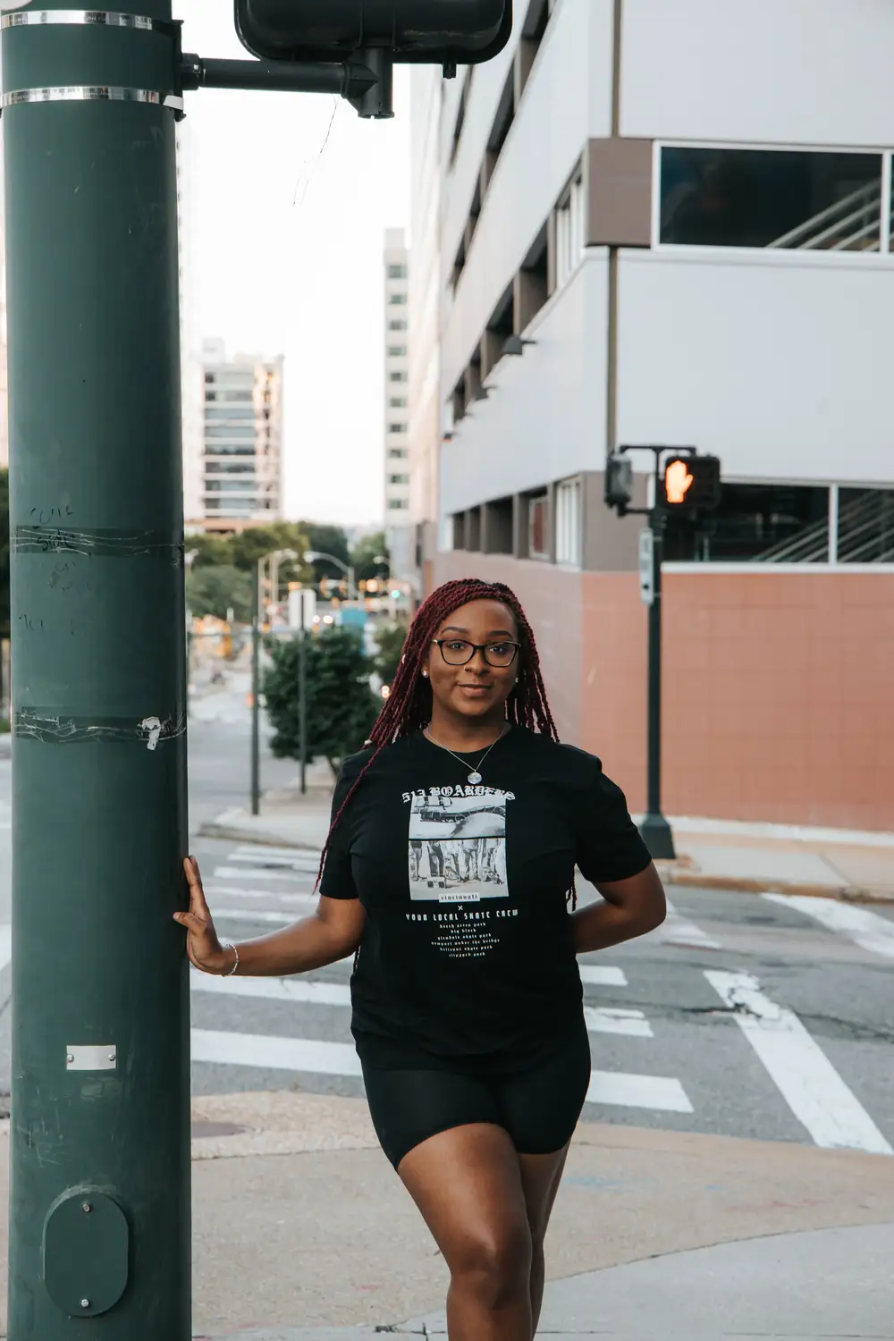 Young woman on braids by a pole