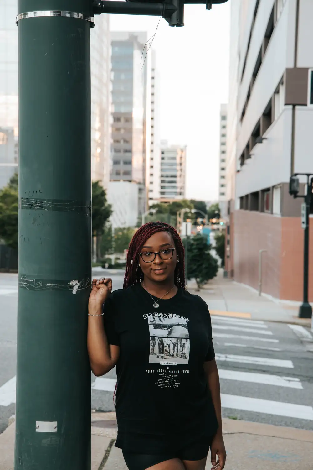 Young lady leaning on a pole