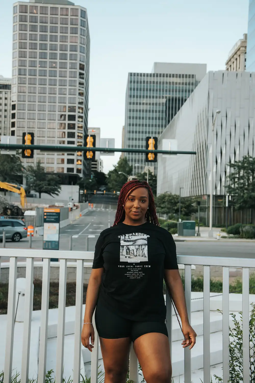 Young woman wearing a black shirt in front of tall buildings