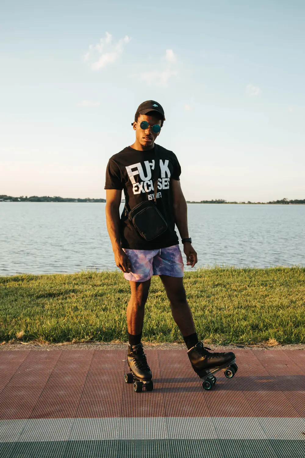 Black African wearing a black shirt and a rollerskater by a river
