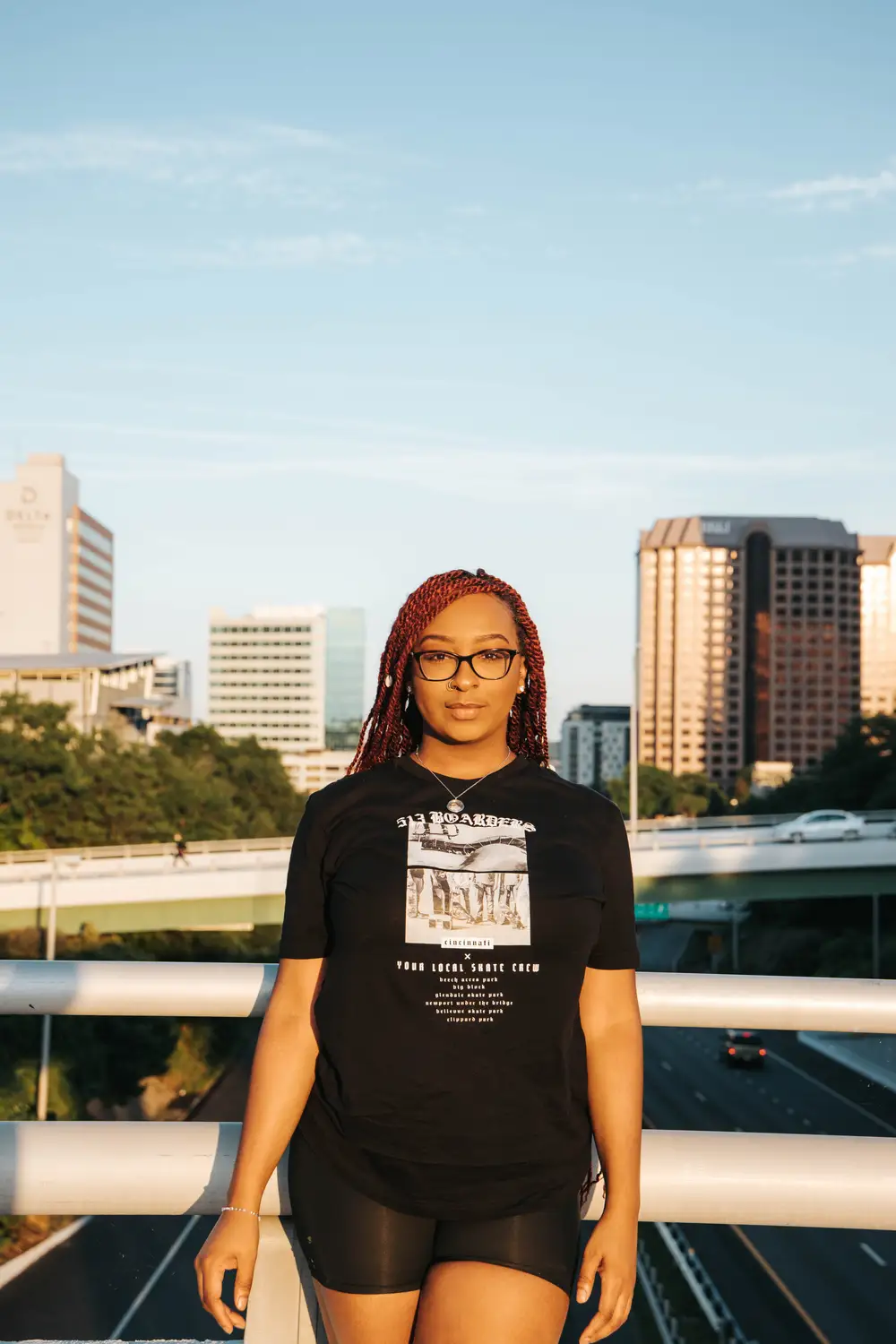 Young lady wearing a black shirt and glasses on a bridge