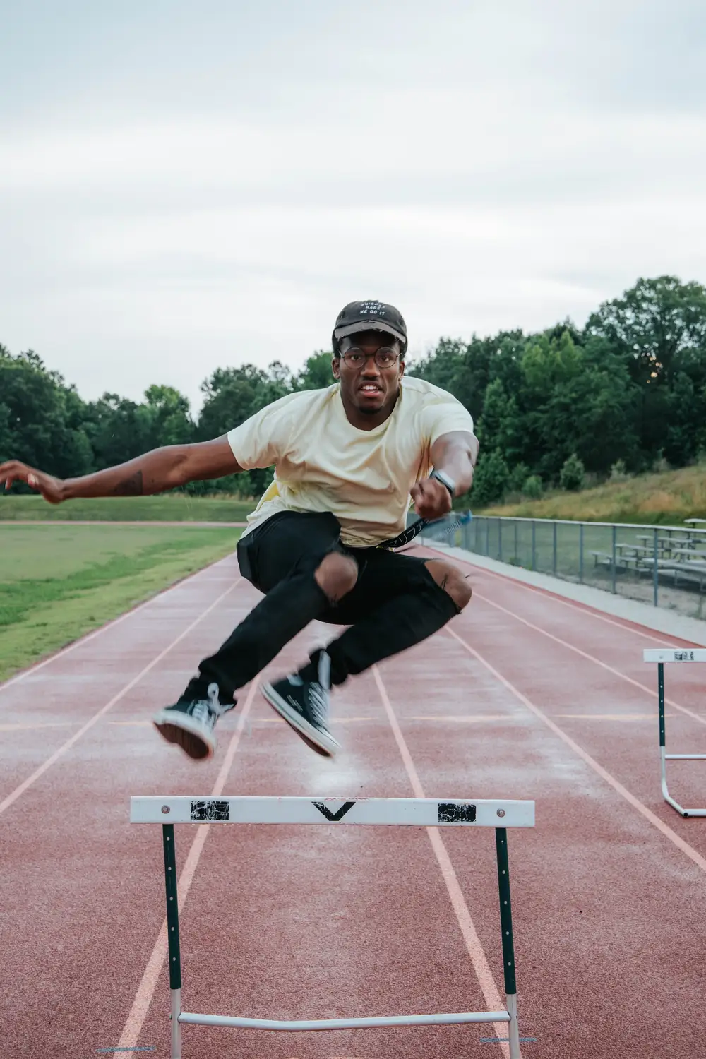 Black man attempting to jump a hurdle