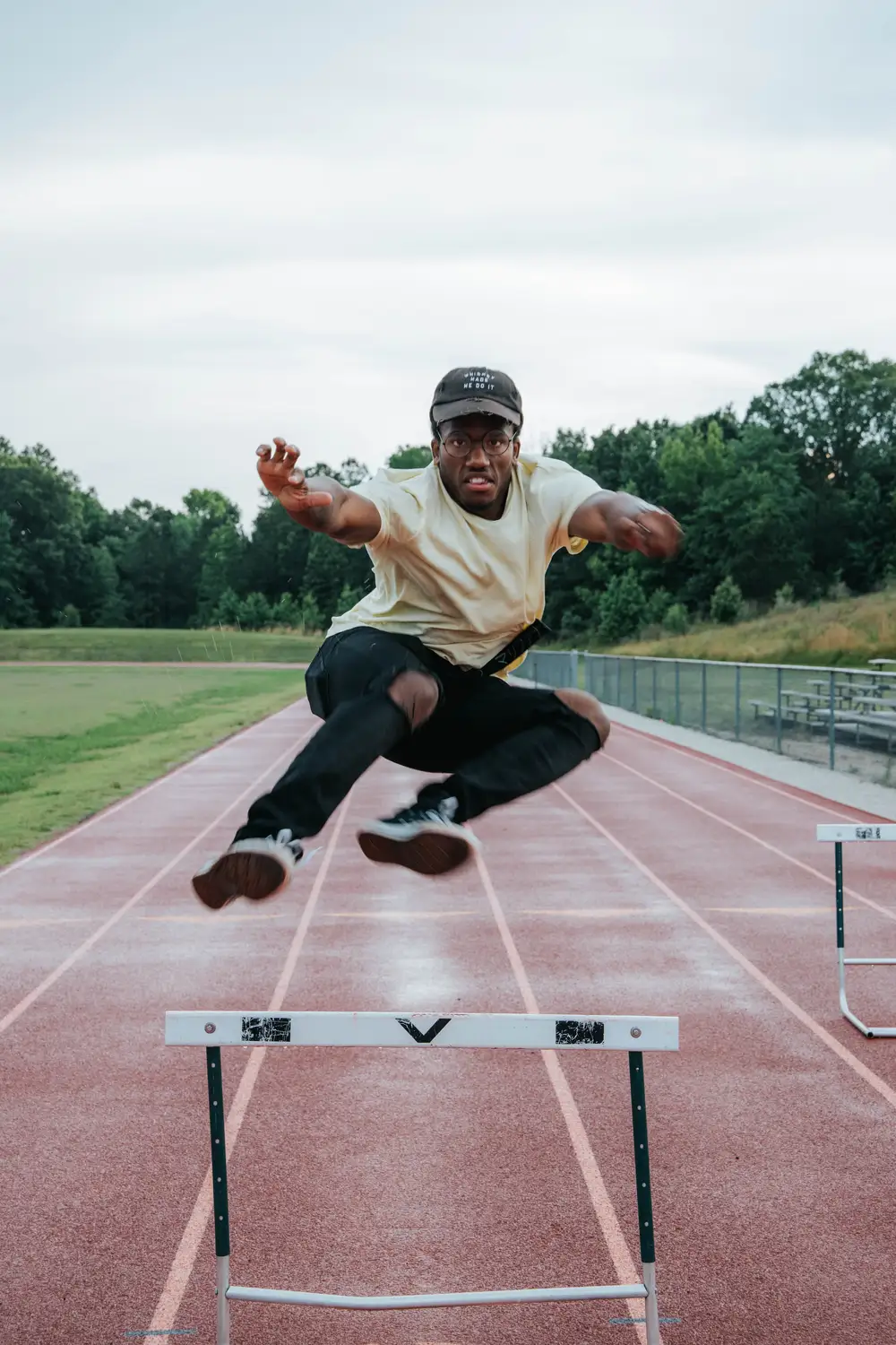 Young man jumping over a hurdle