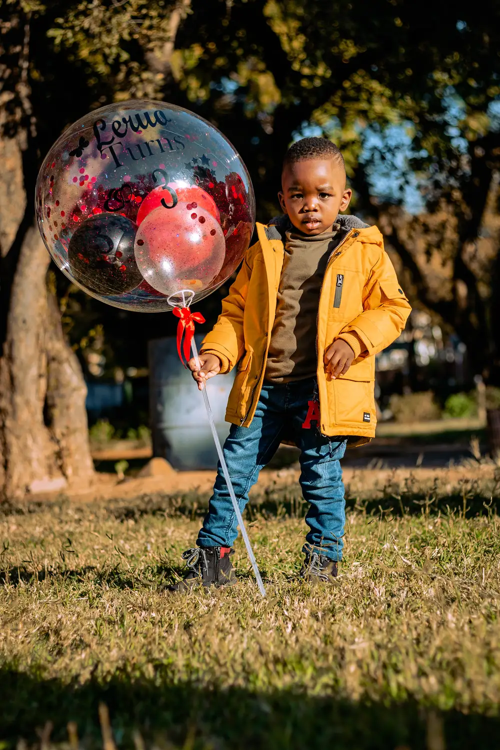 boy standing next to a ballon