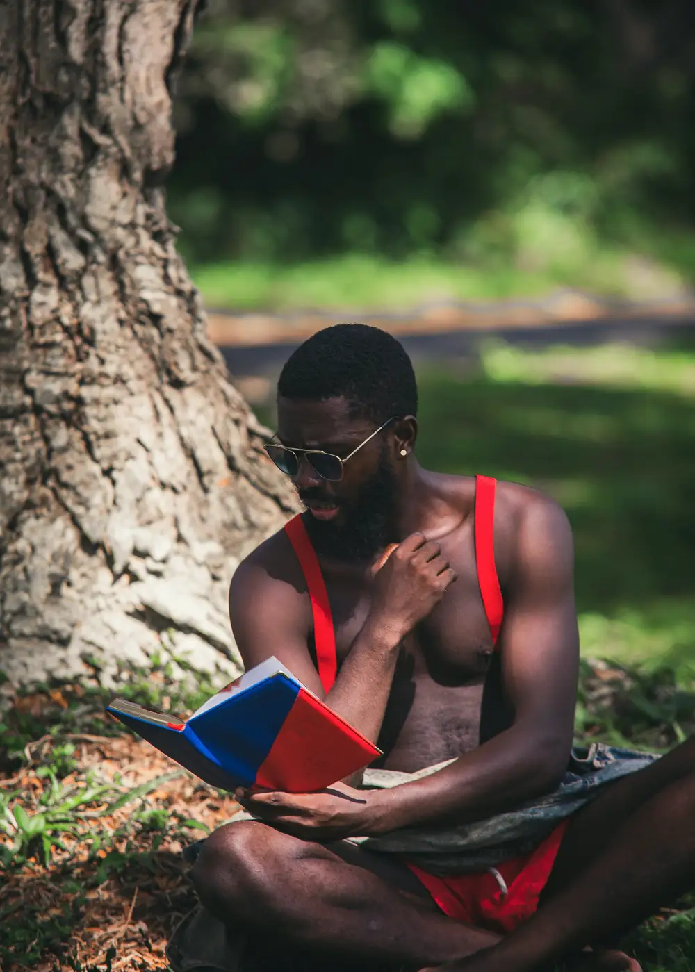 Man reading beside a tree