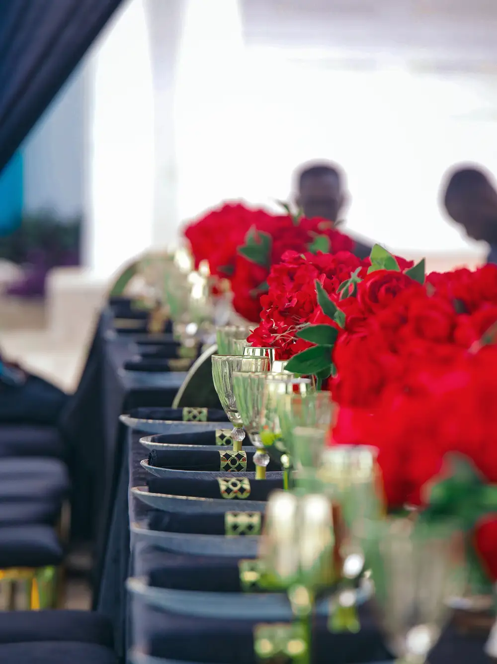 Glass cups beside red flowers