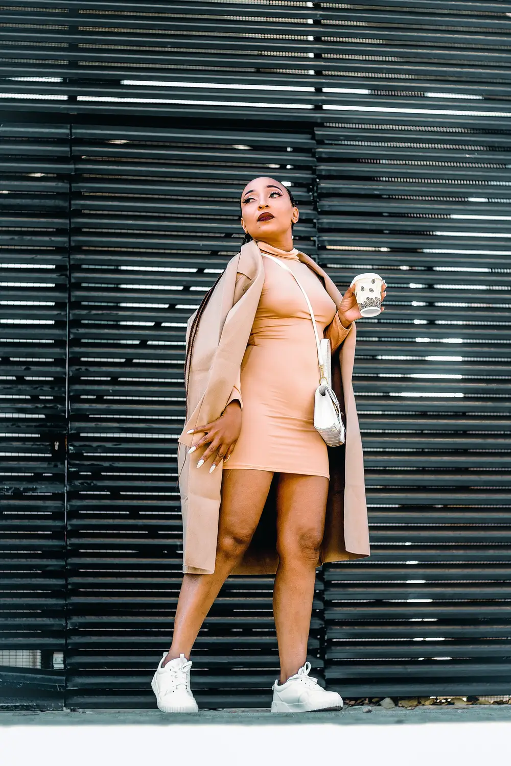 Girl wearing a pink coat and carrying a white bag