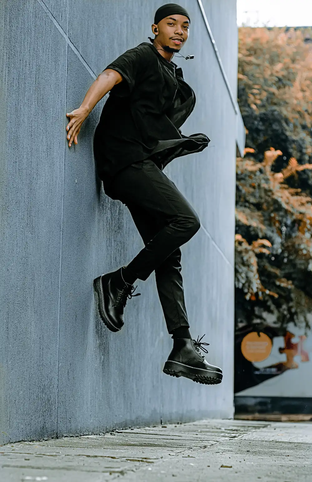 Boy in black standing on a wall