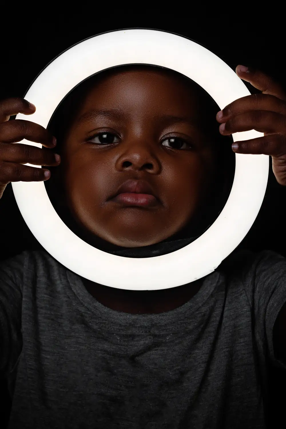 Child holding a ring light