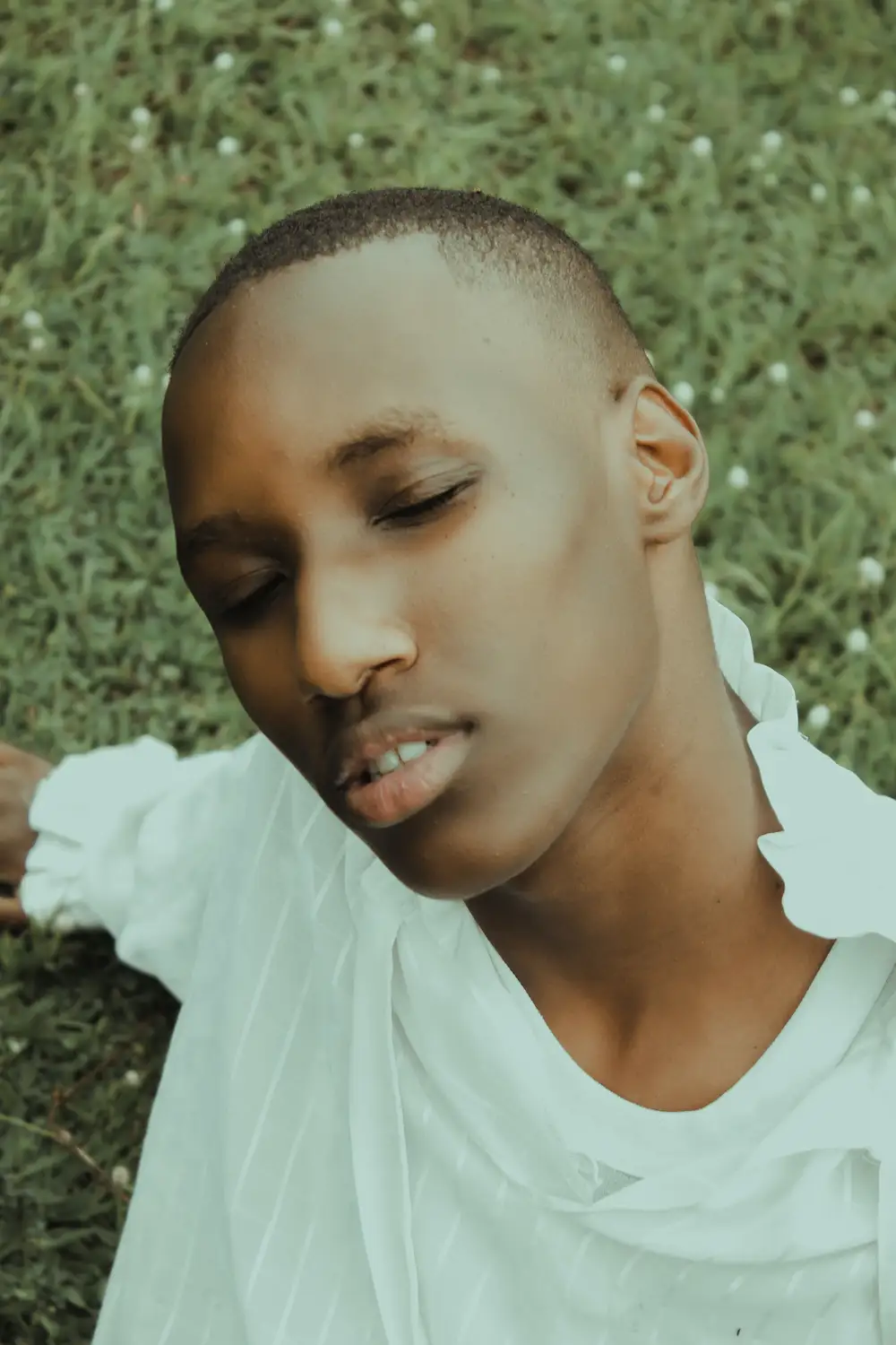 Man Lying on Grass With Eyes Closed