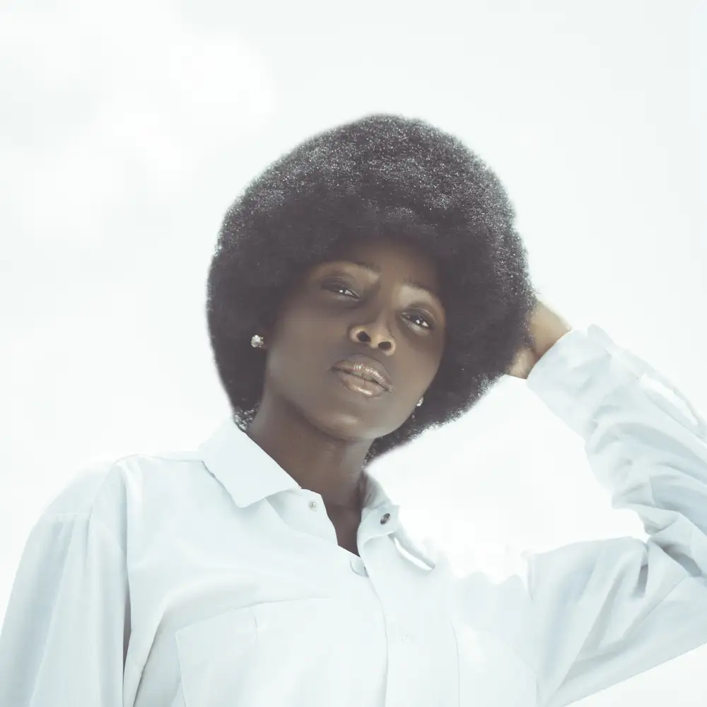 woman in afro wearing a white shirt