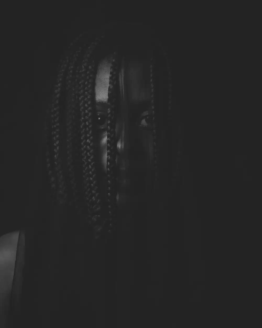 woman in the dark with braids