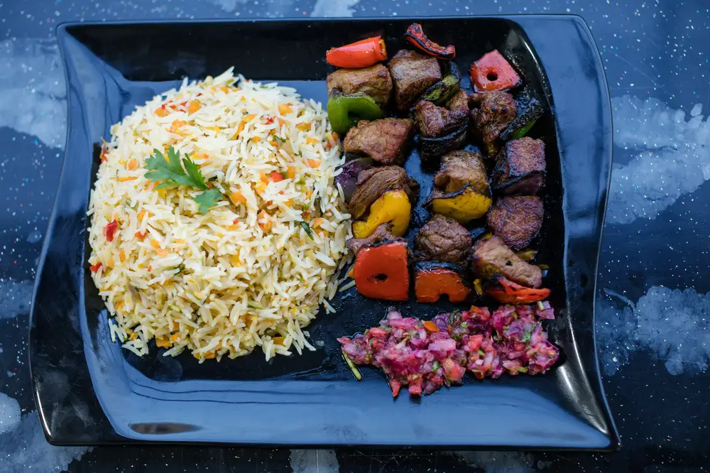 Rice and vegetable dish with chopped grilled meat