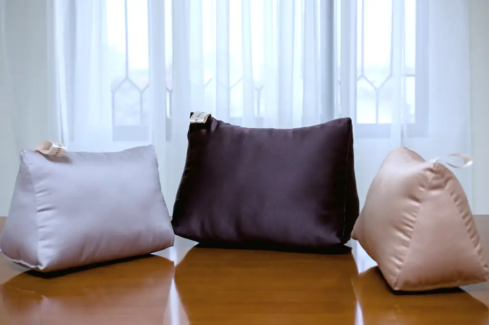 Three silk covered pillow cases of different colors