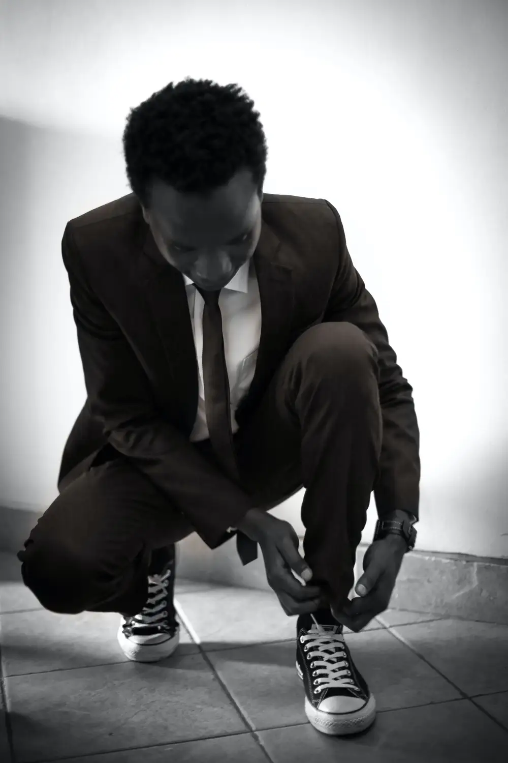 Young man lacing his shoes