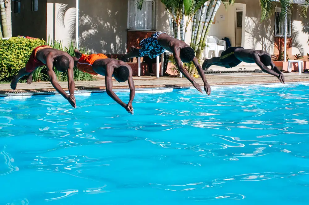 Men jumping in a pool