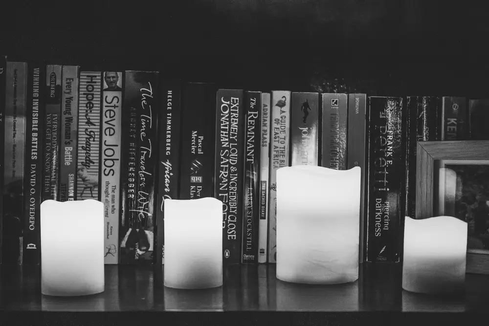 Candle in front of a bookshelf