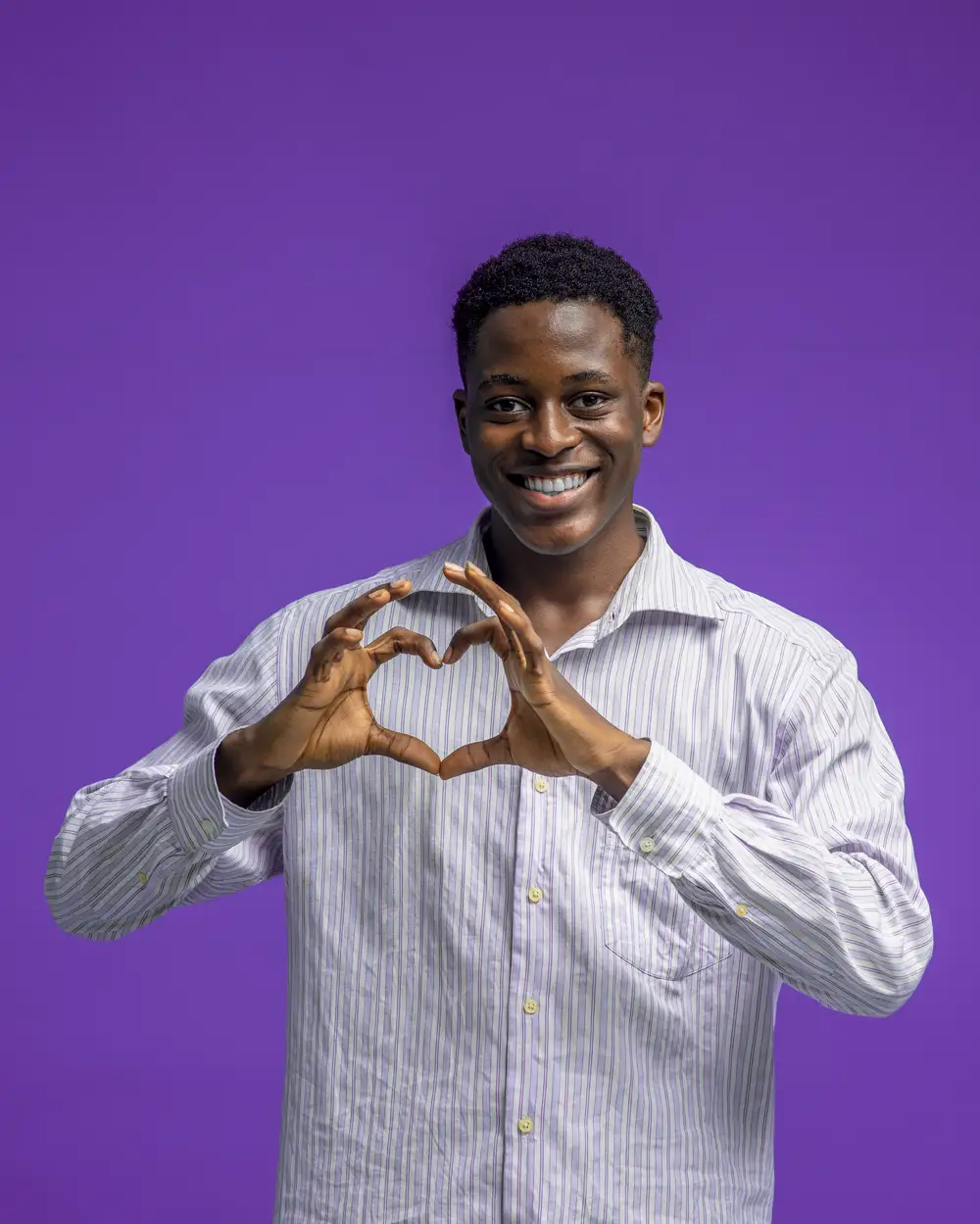 Young boy showing love sign with hands